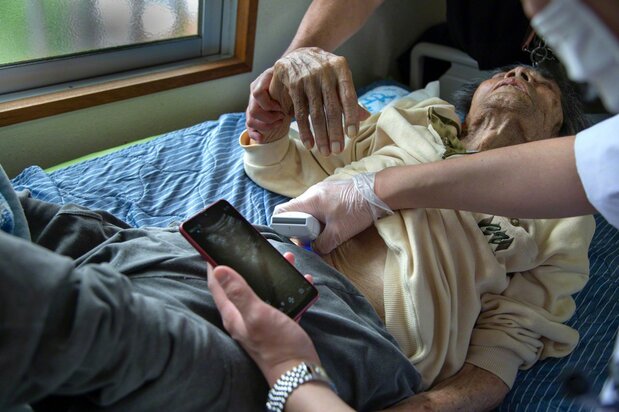 Examinando el abdomen de un paciente con el ecógrafo portátil.