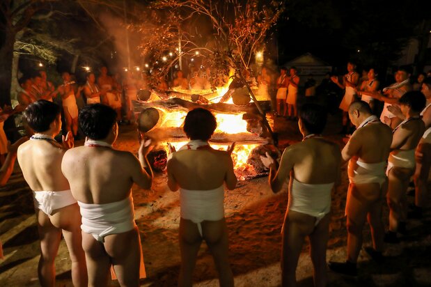 The men circle the bonfire in the finale to an exciting festival. (© Haga Library)