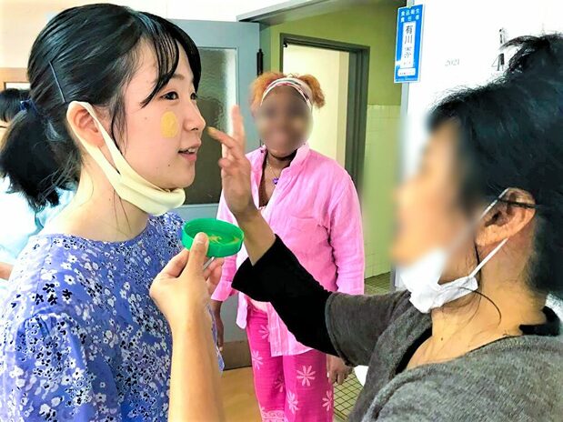 Oikawa mientras le colocan crema facial thanaka de Myanmar. Siempre está dispuesta a acercarse a la cultura de los residentes. Fotografía de Oikawa Izumi.