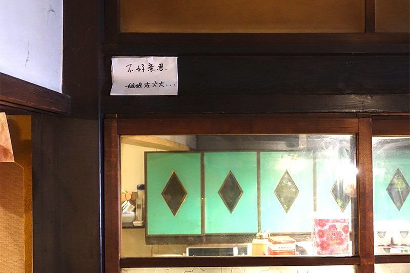 中国語で「ごめんなさい、妻の機嫌は悪い」と書かれた紙が鴨居に貼ってある（撮影：今井 さき）