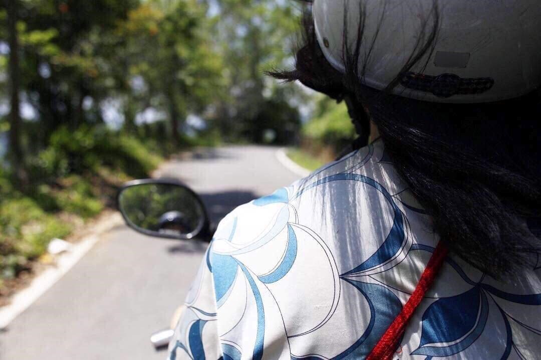 曲がりくねった山道をバイクで走る筆者（野崎志乃撮影）