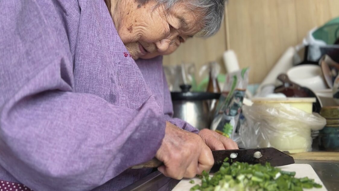 年季の入った包丁でネギを切る　©「104歳、哲代さんのひとり暮らし」製作委員会
