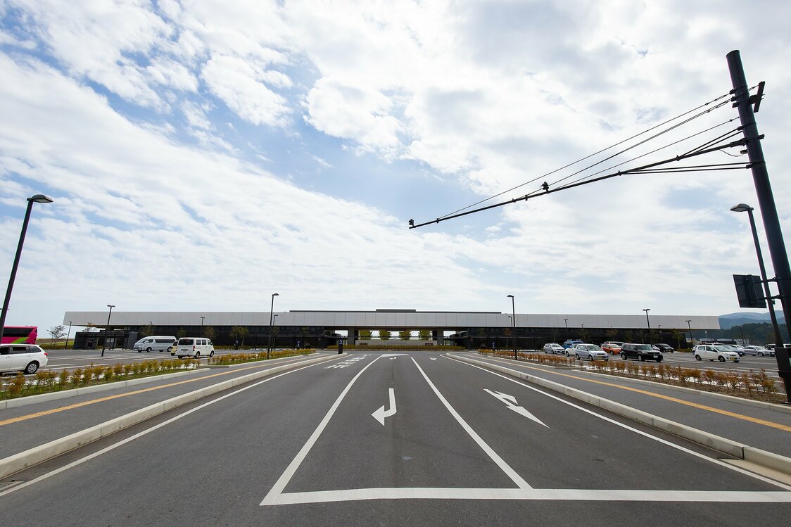 El Museo Conmemorativo del Tsunami del Gran Terremoto del Este Japón (parte izquierda del edificio) visto desde el estacionamiento del Parque Conmemorativo de la Reconstrucción del Tsunami Takata Matsubara. A la derecha se encuentra la estación de servicio Takata Matsubara y pasando el túnel del centro encontraremos la Plaza del recuerdo, el mirador hacia el mar, un altar para ofrendar flores y el pino milagroso, en este orden.