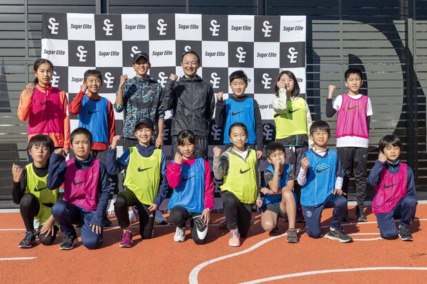 陸上教室に参加した小学生と記念撮影に応じる大迫傑(Sugar Elite提供、2020年12月20日、東京都内)時事