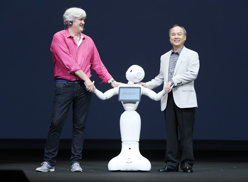 感情認識機能を搭載したロボット「Pepper（ペッパー）」を発表するソフトバンクの孫正義社長（右端）と子会社の仏アルデバラン社のブルーノ・メゾニエCEO（2014年6月5日/時事）