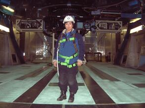 Hayashi Saeko in 2002, photographed in front of the Subaru Telescope. She is wearing a safety harness necessary to operate an aerial lift for the direct inspection of the primary mirror. (Photo courtesy of Hayashi Saeko)