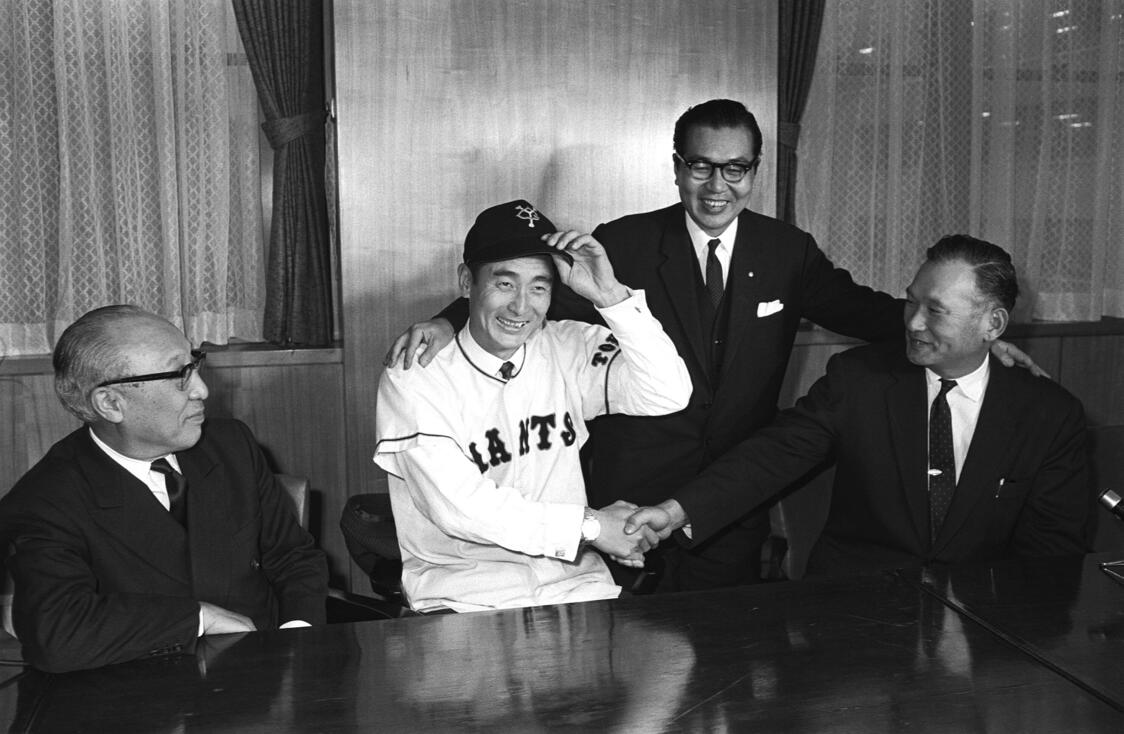 巨人に移籍し、川上哲治監督（右端）と握手する金田正一投手＝1964年12月23日、東京・読売新聞社（時事）