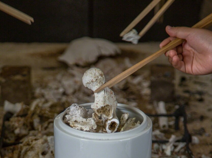 Transferring the bones to an urn after cremation at a Buddhist funeral in Japan. The physical flesh of this world becomes the biomineral of bone as the soul crosses over to the other shore. (© Ōnishi Naruaki)