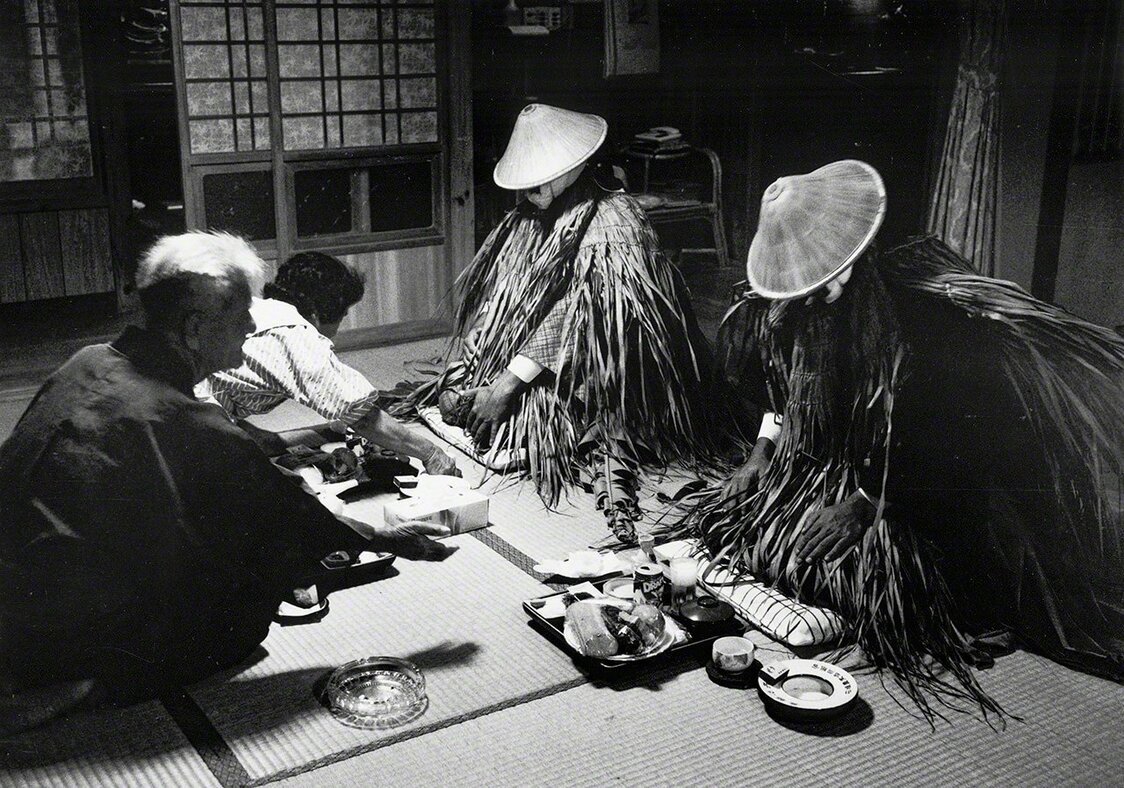 《迎神宴》。这是冲绳县石垣岛川平地区的新年传统活动。村民设宴款待从大海彼岸“尼拉伊”（冲绳民俗中传说的极乐净土）之国而来的神明。画面传递出人与神明密切交流的庄重感（摄于1988年）