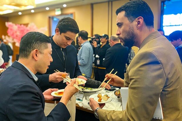 Buyers at a JETRO event in Los Angeles sample Japanese scallops in March 2024. (Courtesy JETRO)