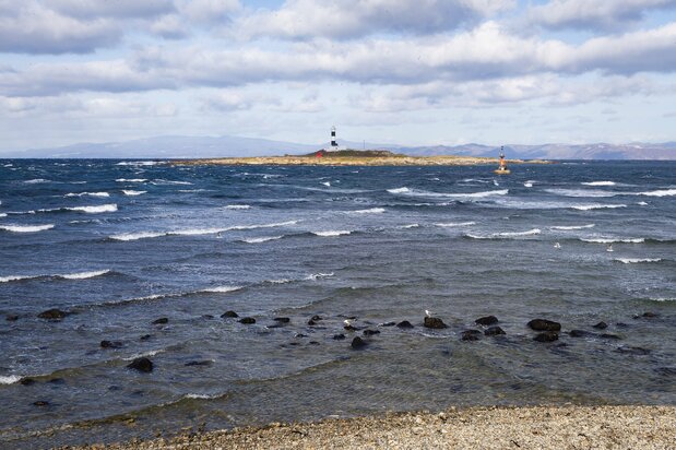 下北半島北端の大間崎から津軽海峡を望む。弁天島の大間埼灯台の奥に薄らと見える陸地が、戸井漁港などがある北海道函館市