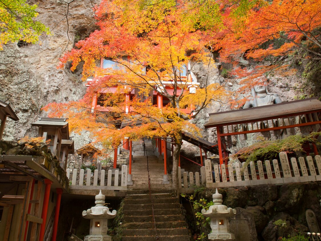 Los colores del otoño en Sekimondō, uno de los ocho paisajes de la ruta trasera. En la pared rocosa hay una estatua de piedra de la deidad budista Fudō Myō-ō.