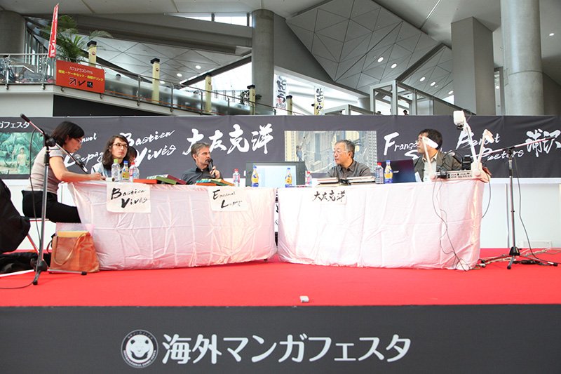 النقاش العلني، الجزء الأول. هارا ماساتو، مترجم القصص المصورة (BD) في دور الوسيط (يمين).