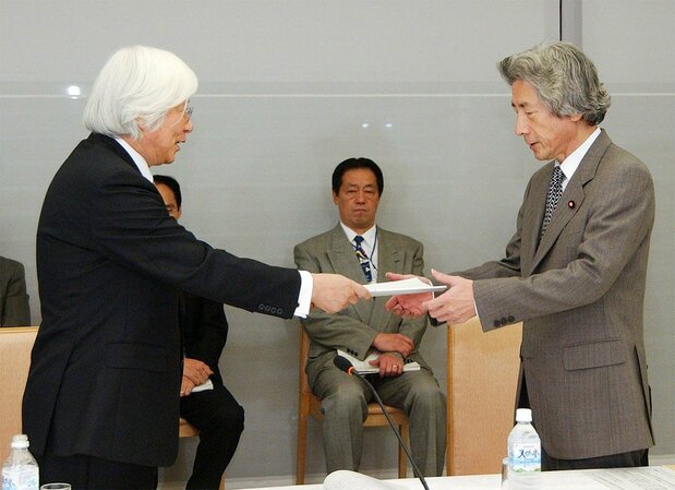 「皇室典範に関する有識者会議」の吉川弘之座長（左）から報告書を受け取る小泉純一郎首相＝2005年11月24日、東京・首相官邸（時事）