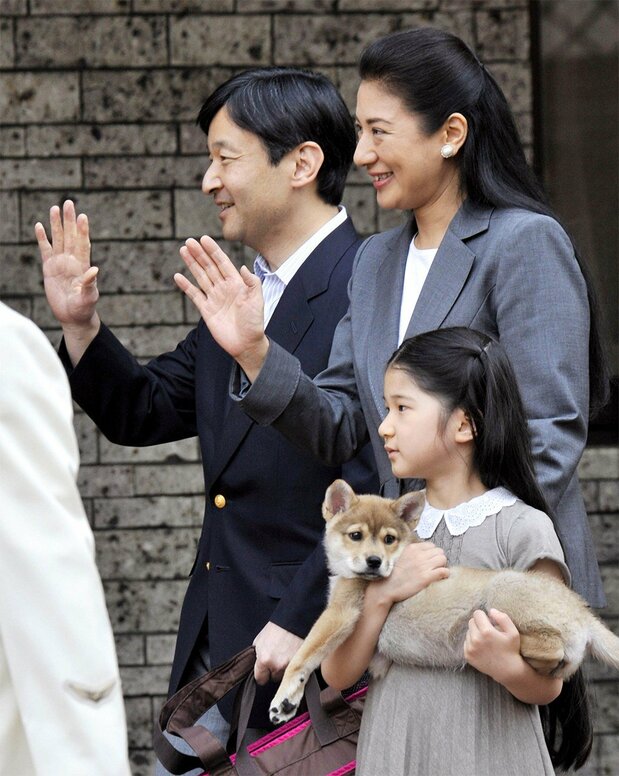 Aiko tient dans ses bras la chienne Yuri, recueillie d’une clinique vétérinaire à l’âge de deux mois. La famille est en route vers la ferme impériale, en mai 2009 (Jiji).