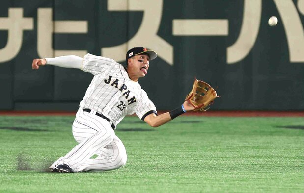 Japan center fielder Lars Nootbar makes a catch during the team’s opening game against China. (© Jiji)