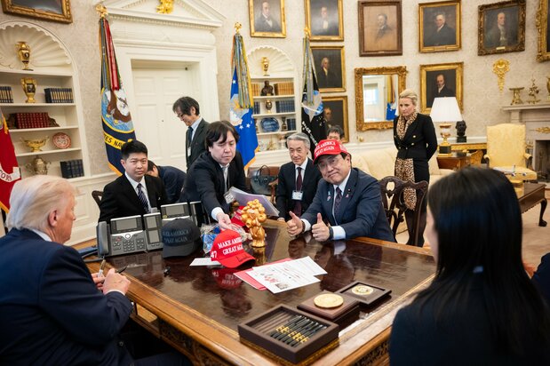 トランプ大統領がサインしたMAKE AMERICA GREAT AGAINキャップをかぶってポーズをとる赤沢亮正経済再生担当相（2025年4月16日）（ZUMA Press Wire via Reuters Connect）