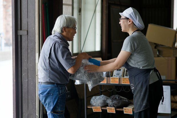 De nombreux voisins achètent des grands sacs en format économique. (© Nomura Kazuyuki)