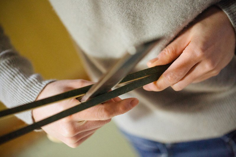 أوغورا تستخدم سكين ذو نصل عريض لتقطيع الخيزران لتكوين خصلات رفيعة