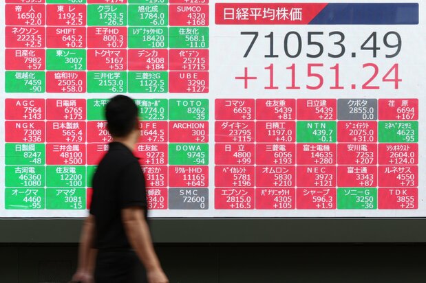 終値が初めて7万円を超えた日経平均株価を示すモニター=18日、東京都中央区(時事)