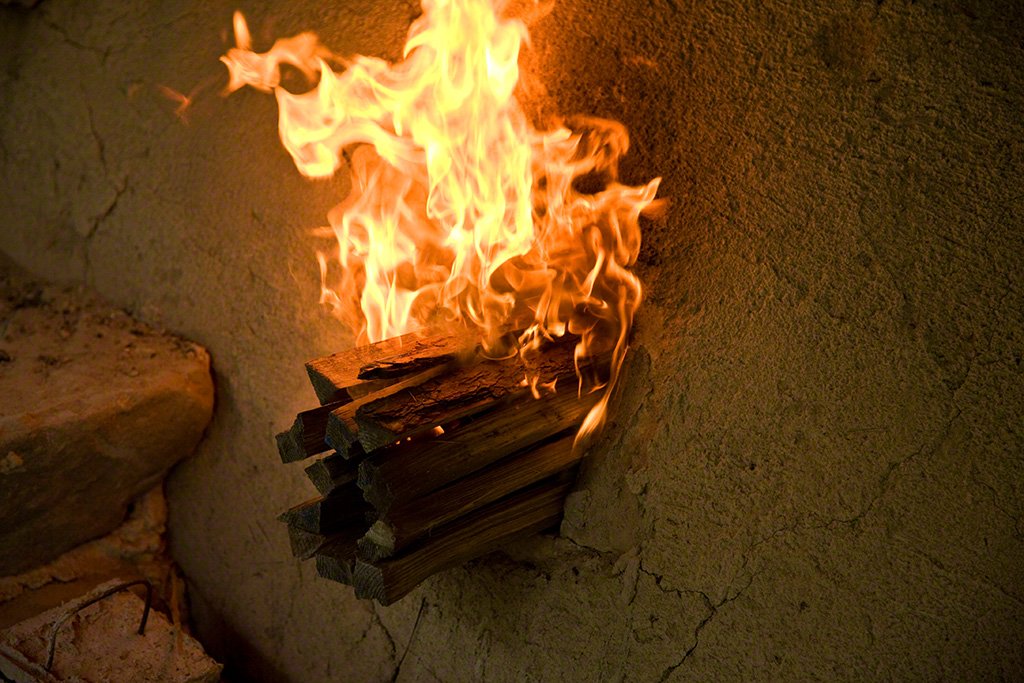 Red pine inserted to fire the kiln—its high resin content helps the fire burn strongly.