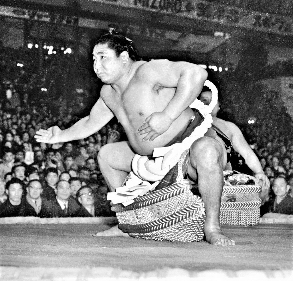Wakanohana I makes his first ring entrance as yokozuna at the spring 1958 basho. Despite being comparatively light, he was popular for his dynamic moves. Together with fellow yokozuna Tochinishiki, he ushered in the first postwar golden age of sumō. (© Kyōdō)