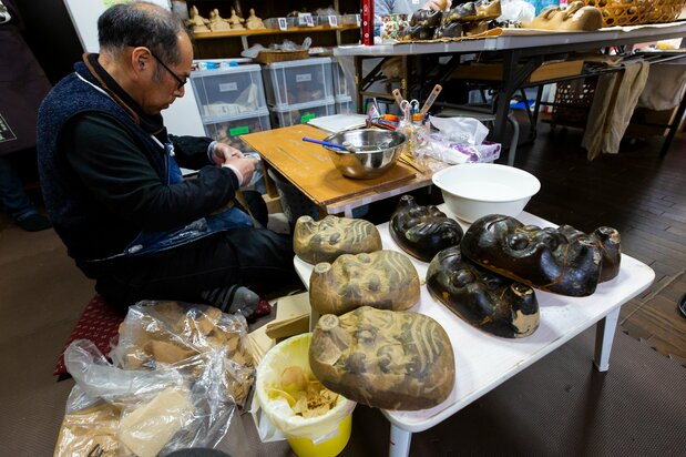 Des pièces de bois qui donneront leurs formes aux masques hyottoko, représentation humoristique d'un homme parfois utilisée pour des danses lors de festivals locaux. Pour faciliter le retrait du papier washi, l’artisan applique avec soin une couche d’huile sur ces pièces de bois qui ont noirci au gré des époques.