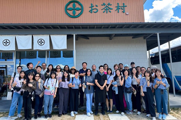 Ôishi Kenichi (au premier rang au centre, avec un polo noir) accueille des visiteurs étrangers au café/point de vente de sa plantation. (Avec l’aimable autorisation de Ôishi Tea Factory)
