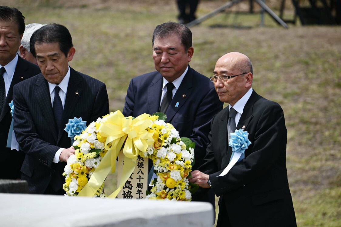 El primer ministro Ishiba (en el centro) realiza una ofrenda floral en una ceremonia conmemorativa en Iwojima (Iōtō). (© Jiji)